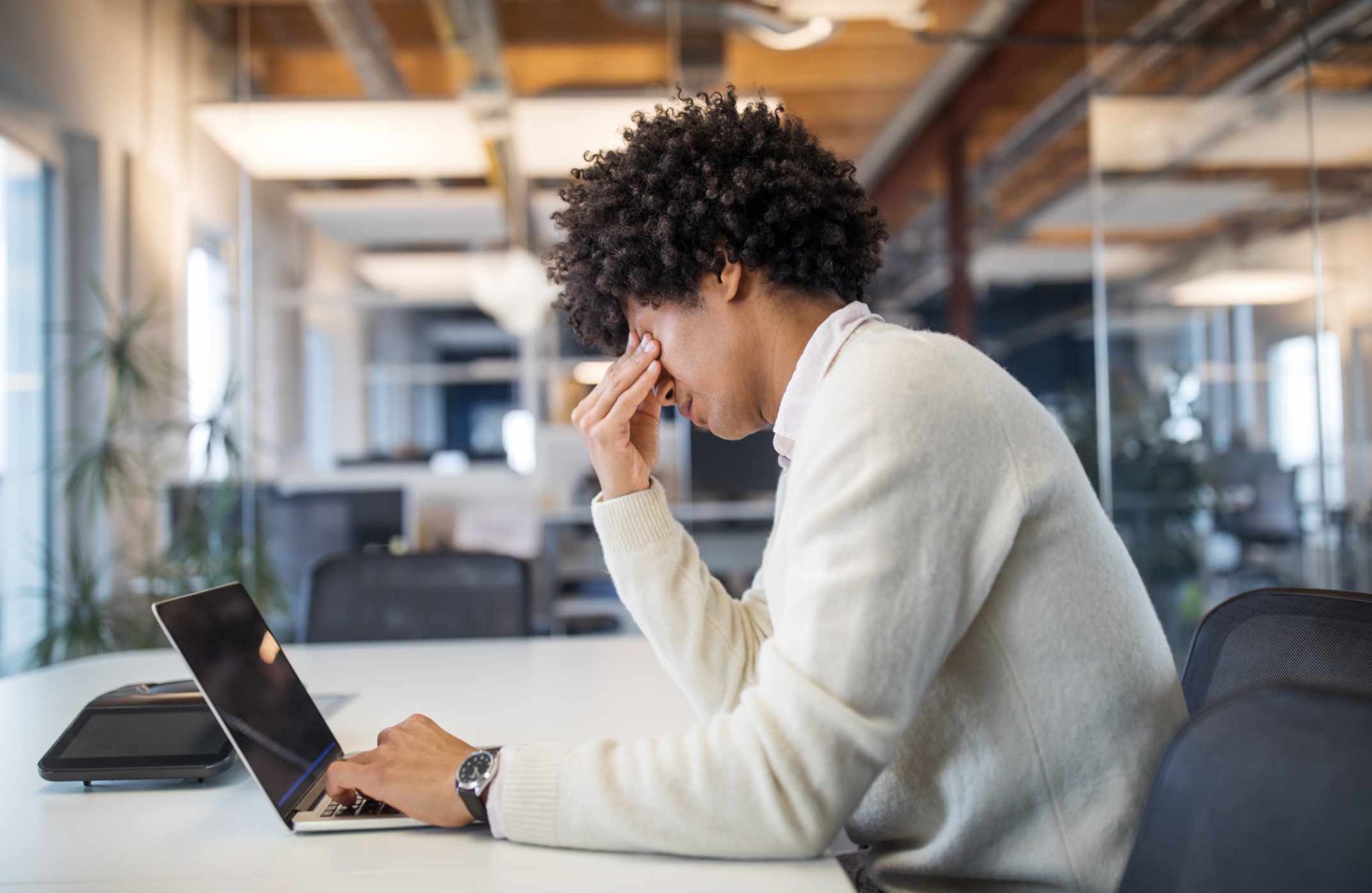 Person experiencing stress while working at a laptop