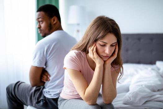 Two people sitting apart while experiencing emotional stress